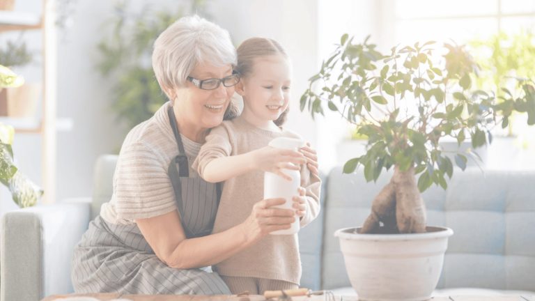 Grandmother and granddaughter planting a tree.